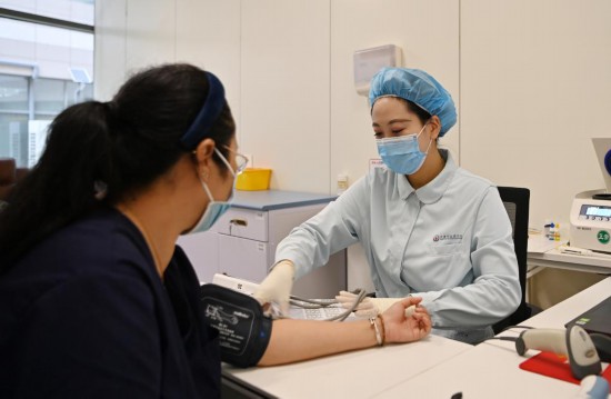 2023年8月8日,天津市血液中心的工作人员在健康广场给献血者测量血压。新华社记者 李然 摄